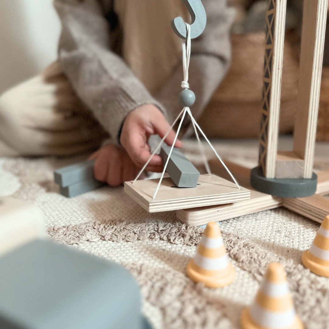 Fából készült építkezés nagy mobil daruval és járművekkel, toronydaruval