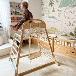 Fedett, fából készült játszótér hintával, tornagyűrűkkel és mászóhálóval