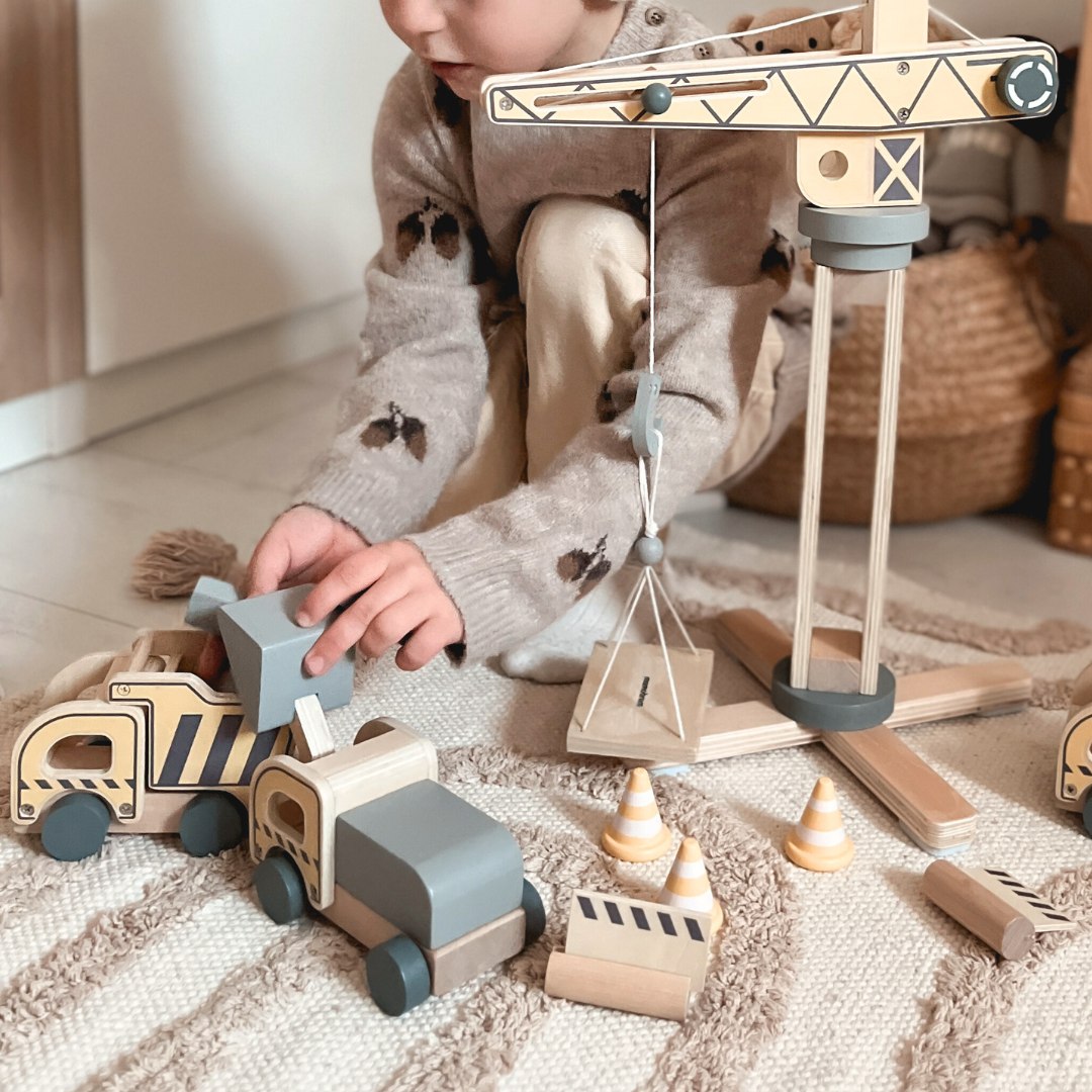 Fából készült építkezés nagy mobil daruval és járművekkel, toronydaruval